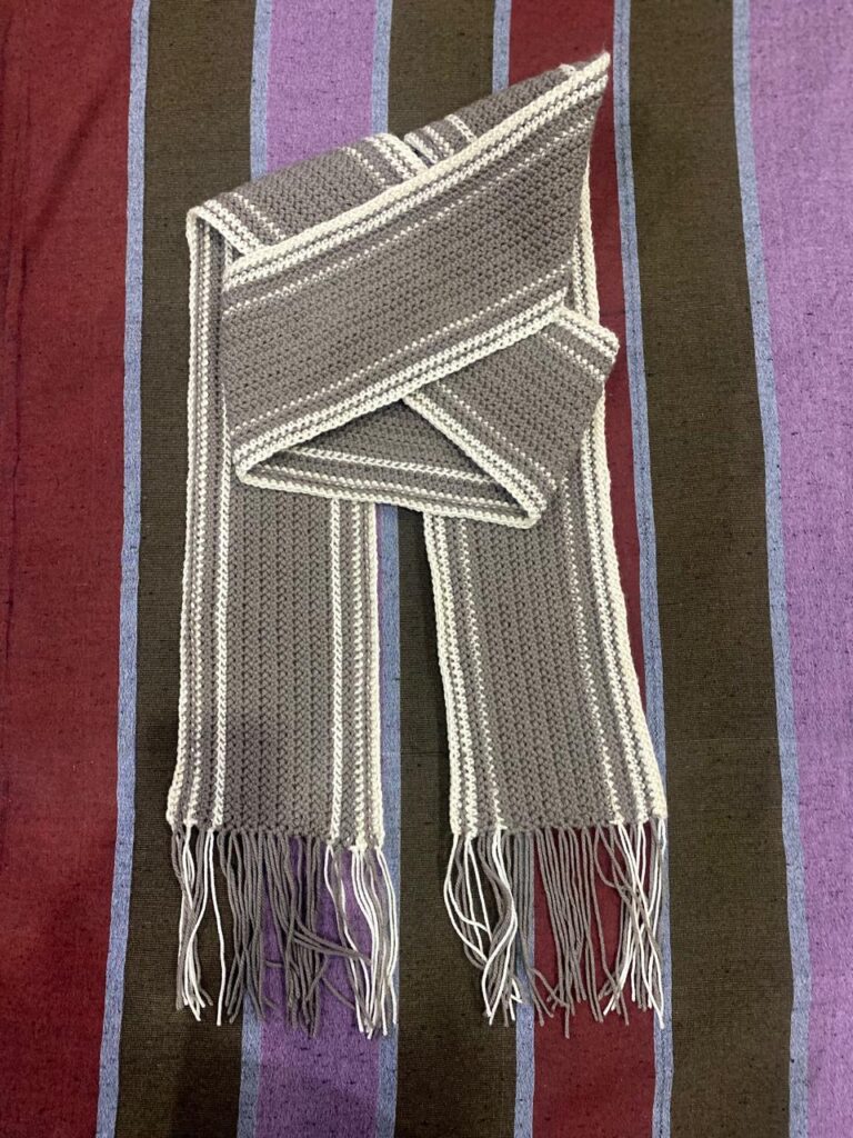 Handmade crochet scarf with yarn and crochet hook